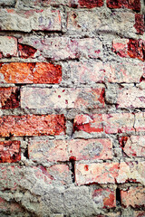 Old red brick masonry with traces of destroyed plaster.