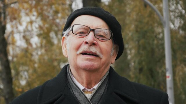 Handsome Elderly Senior Taking Deep Breath. Old Man Relaxing Breathing In Fresh Crisp Air In Park, Smell The Tree, Connect With Nature.