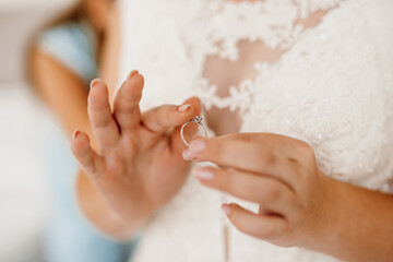 the bride gently touches her dear engagement ring