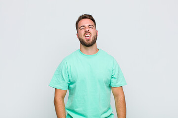 young man feeling disgusted and irritated, sticking tongue out, disliking something nasty and yucky