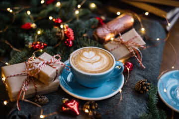 Delicious fresh festive morning cappuccino coffee in a ceramic blue cup on the warm cover with...