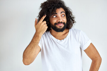 thoughtful suspicious young man looking aside isolated on white background, arabic guy with long...