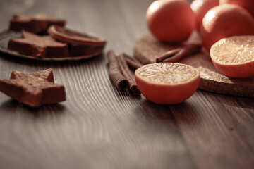 Tangerines, cinnamon sticks, dried oranges and star cookies on a brown wooden background. Christmas atmosphere, lifestyle concept