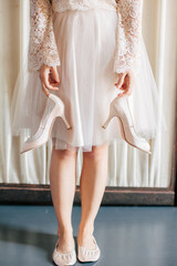 Closeup of bridesmaid wearing flats holding her heels in front of her