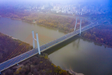 Aerial drone view. bridge  in the rays of a sunny morning. Autumn haze in the air, cars are driving across the bridge.