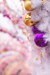 Christmas background of gold and purple balls and garlands, bokeh. Concept of greeting cards for New year, Christmas and thanksgiving. Vertical format, shallow depth of field