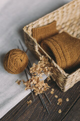 A pair of hand knitted socks in a basket,  knitting needles and yarn ball.  Background for handmade...