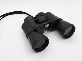Black travel binoculars on a light background
