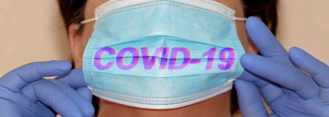 covid-19 text on surgical mask, woman during the coronavirus pandemic in a hospital