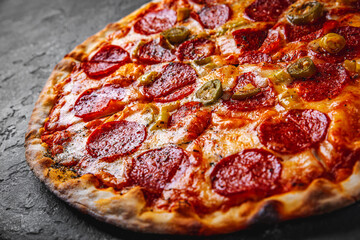 Pepperoni Pizza with Mozzarella cheese, salami, Tomato sauce, pepper, Spices. Italian pizza on Dark grey black slate background