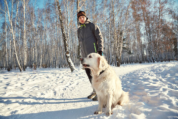 Labrador retriever dog for a walk and training with owner man in the winter outdoors - 394771949