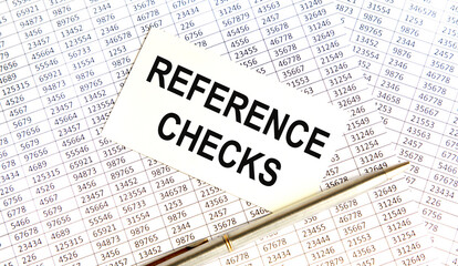 Obraz premium On the card text REFERENCE CHECKS, next to the pen, reports.