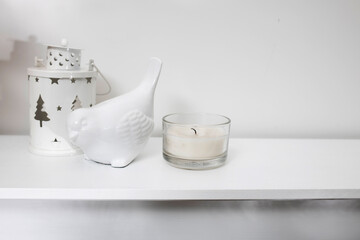 Candle, white candlestick in the shape of a lantern and earthenware figurine of a bullfinch