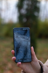 Woman hold broken black phone. Female hand hold broken smart phone. Phone broken touch screen
