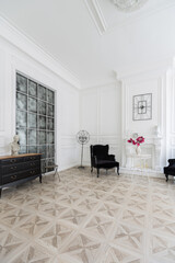 Luxury white interior of living spacious room with elegant chic furniture and high windows.