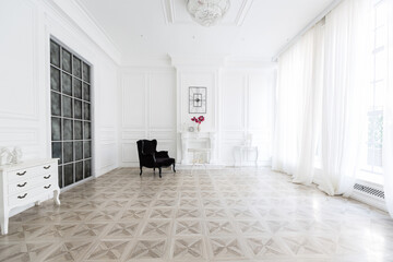 Luxury white interior of living spacious room with elegant chic furniture and high windows.