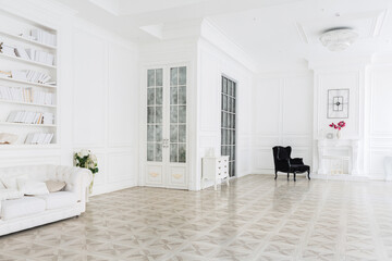 Luxury white interior of living spacious room with elegant chic furniture and high windows.