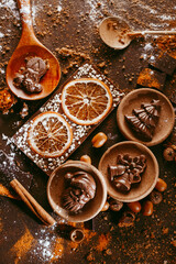 Christmas chocolate figures Santa Claus, Christmas tree, bells, candle are on the dark table