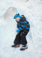 Fototapeta na wymiar funny little boy playing in snow house