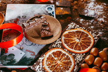 Christmas chocolate figures Santa Claus, Christmas tree, bells, candle are on the dark table