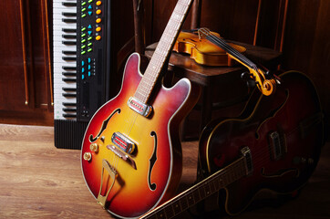 Two jazz electric guitars, violin and keyboard synthesizer in the interior
