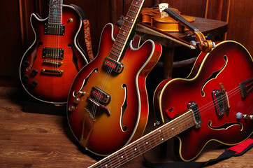 Three jazz electric guitars and a violin in the interior