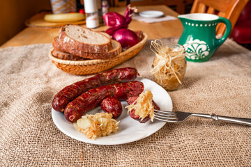 Rustic dining with sausage, horseradish with apple, bread, onion and green pitcher.