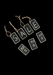 Sale or black friday concept, letters written in chalk on a graphite tag