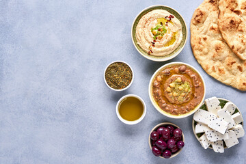 Middle eastern, arabic traditional breakfast with hummus, foul, white cheese and zaatar. Top view ...