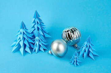 Christmas composition with blue paper fir trees and silver balls