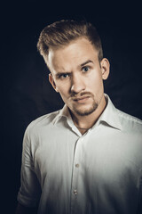 Young man dressed in white shirt studio portrait