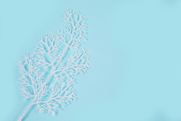 White sprig with sparkles on a blue background.