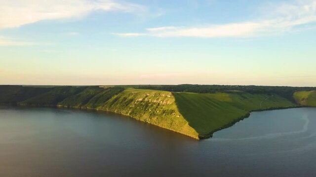 Aerial view of wide Dnister river and distant rocky hills in Bakota area, part of the National park "Podilski Tovtry" in Ukraine
