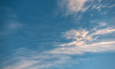 Beautiful evening blue sky, with white cirrus clouds of different shapes