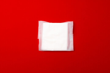 Female medical pad on red background top view