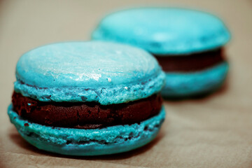 Blue macaroons lie on parchment paper