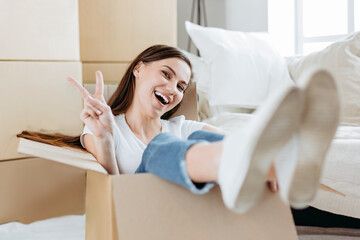 happy young woman sitting in a large cardboard box