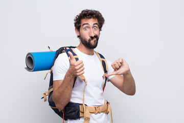 young man feeling confused, clueless and unsure, weighting the good and bad in different options or...