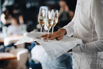 Closeup of glasses with a cool delicious champagne, Waiter with champagne on a tray