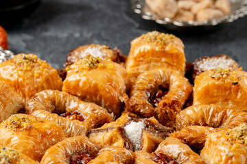 Assortment of turkish baklava on black textured surface