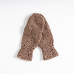 Brown fluffy woolen mittens on white background. Flat lay, top view, copy space