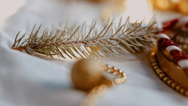 Christmas sweets and treats. Presents. Gingerbread and muffins on a plate with caramel sweets. Christmas toys and garlands on the background, a pine branch in the snow. Close-up. Place for text.