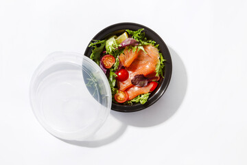 take away box with salmon salad and tomato