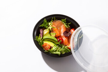take away box with salmon salad avocado and tomato