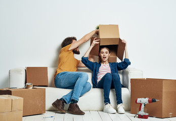 Fototapeta na wymiar Man and woman sit on white couch boxes with moving lifestyle things
