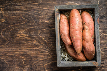 Raw Sweet potato on Wooden table. Wooden background. Top view. Copy space