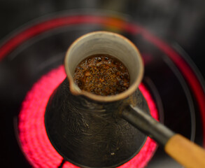 Fototapeta na wymiar Boiling Turkish coffee pot on electric stove