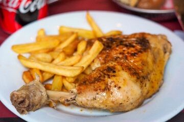 Dinner. Roasted chicken leg with french fries on a plate