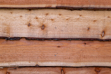 Close up of waney edge wooden cladding boards