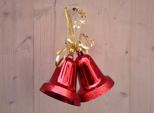Close-up Of Red Bells Hanging On Wooden Wall During Christmas